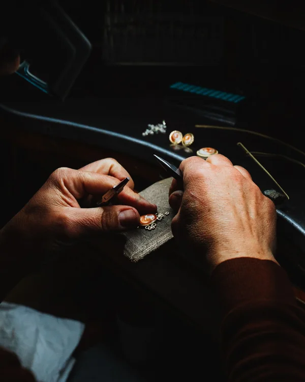 A goldsmith's hands working at a jewellery bench