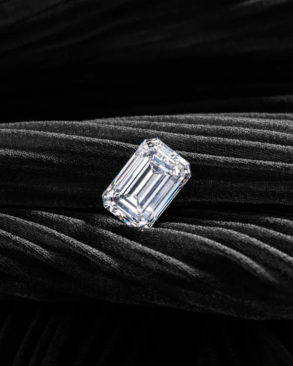 An emerald-cut diamond ring on black fabric
